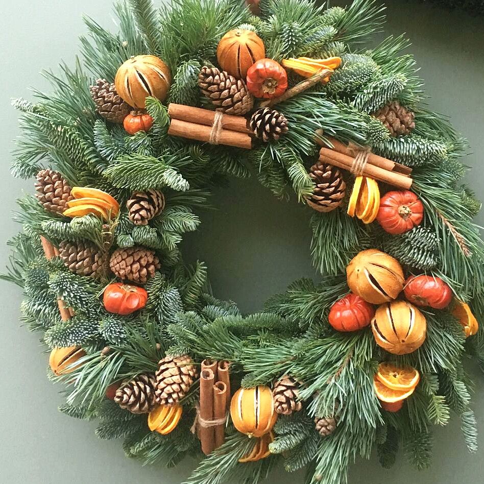 The Victoria Christmas door wreath Sample of The Luxury Victoria Christmas door wreath, mixed pines with dried orange fruits, pine cones and cinnamon sticks available to order from Kensington flowers London